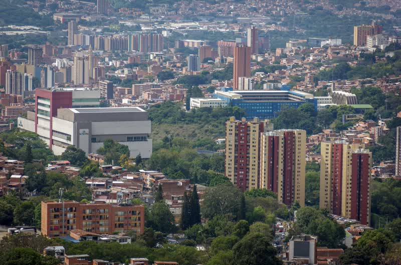 Red-brick apartment towers among green trees in Laureles, Medellín