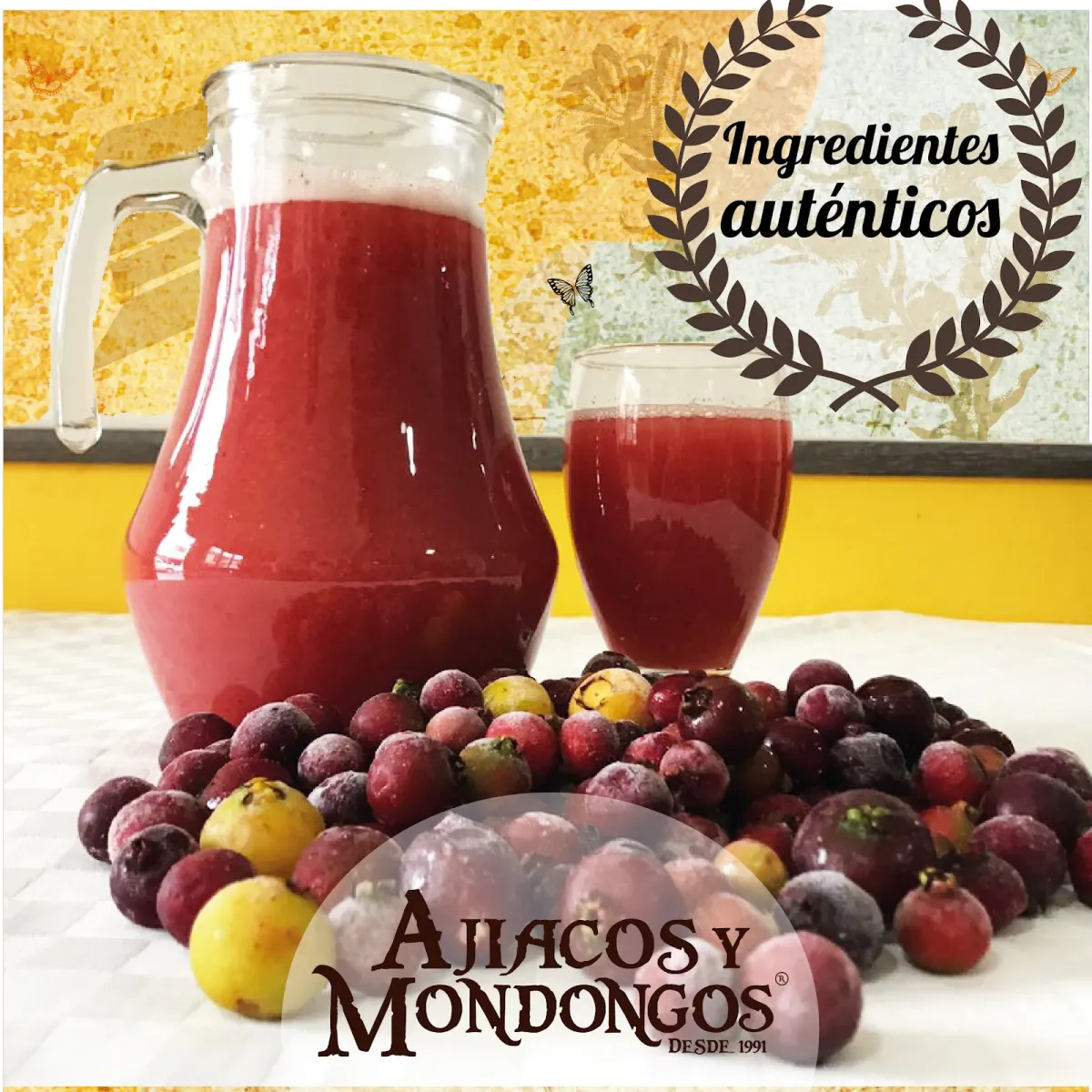A glass jug and glass of red fruit juice behind a pile of red and yellow fruit, in an Ajiacos y Mondongos graphic reading "Ingredientes auténticos"