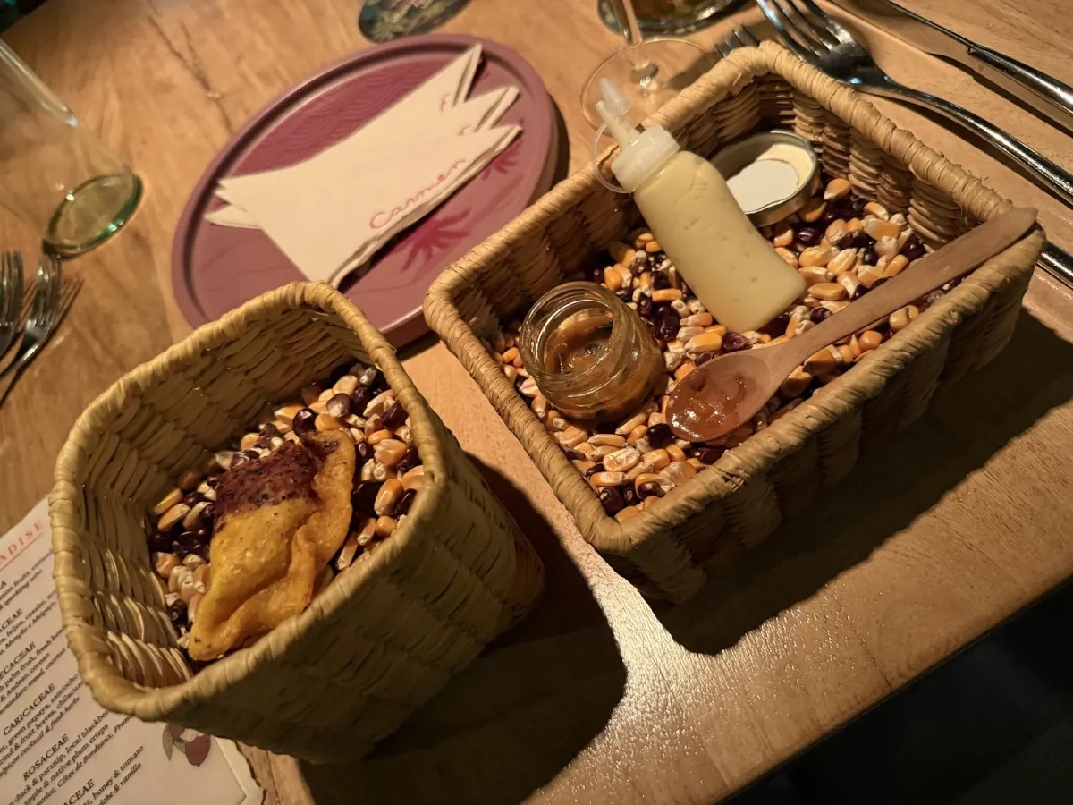 Woven baskets holding grains and bread on a table at Carmen