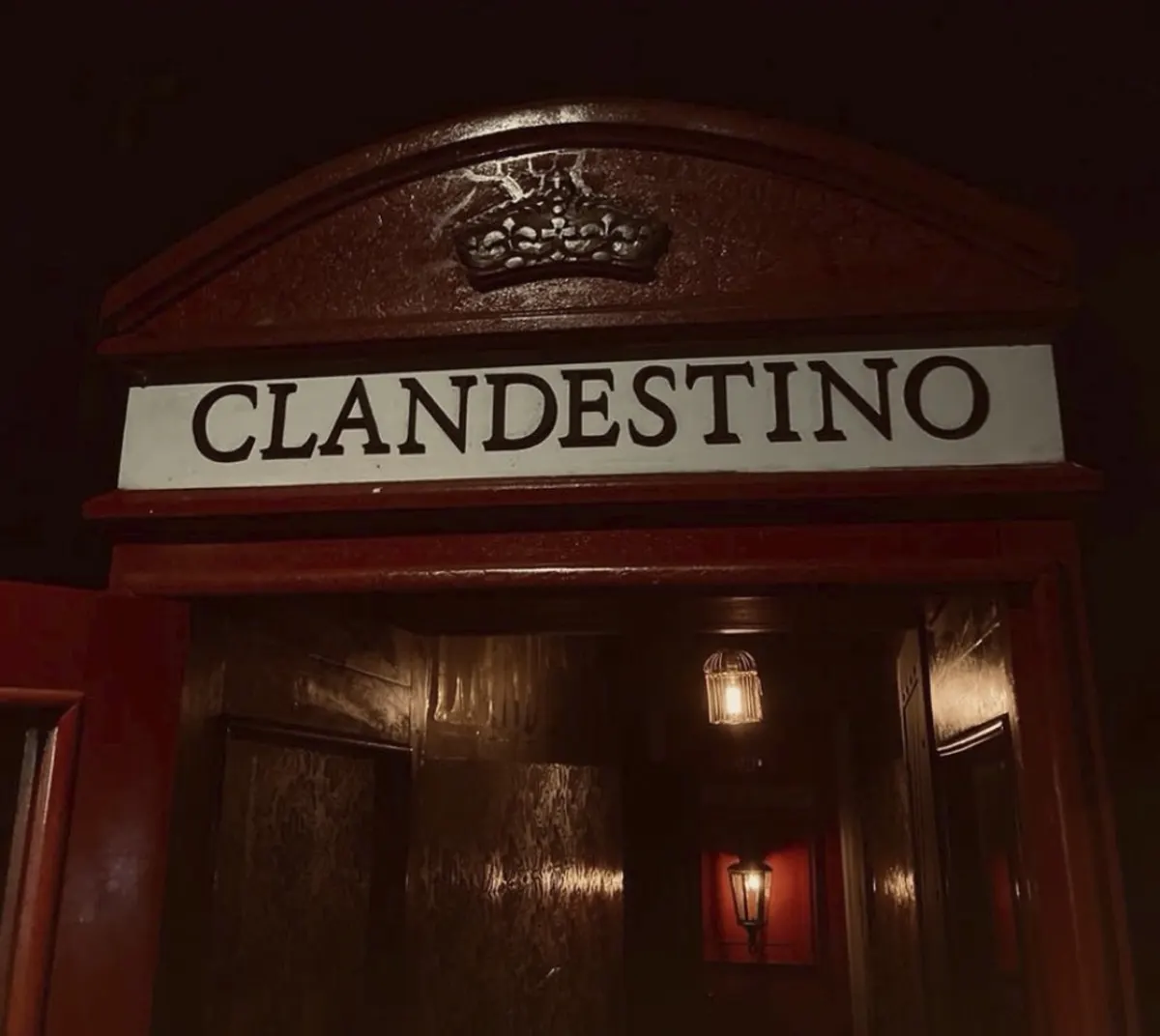 The red front door of Clandestino with its sign above