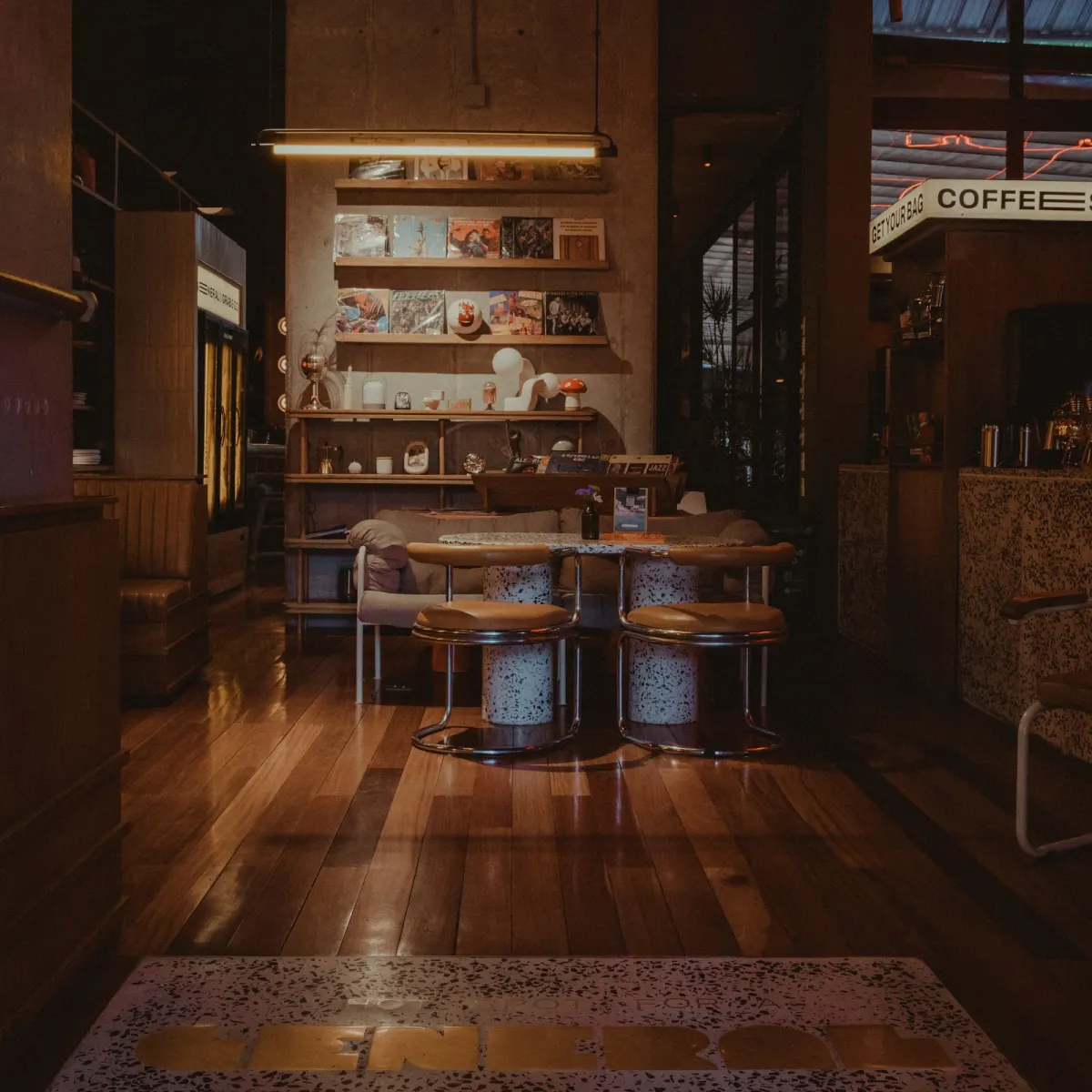 The dark wooden interior of General Café Bar with a lit COFFEE sign