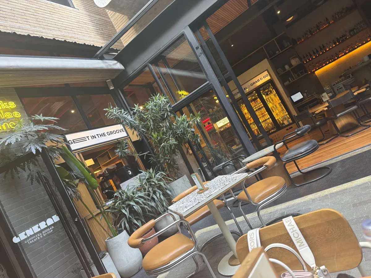 The glass-fronted terrace of General Café Bar, with plants and the GENERAL sign