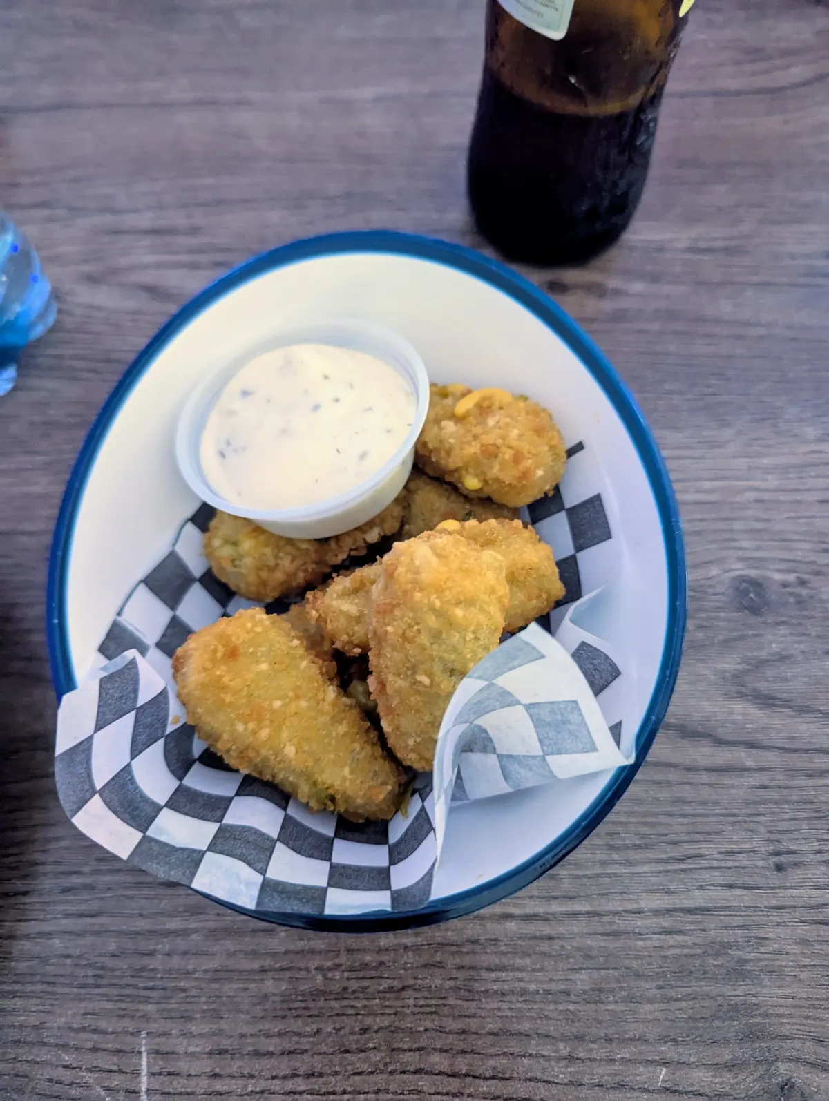 Basket of breaded fried bites with a pot of ranch dip on checkered paper at Medellín Sports Bar