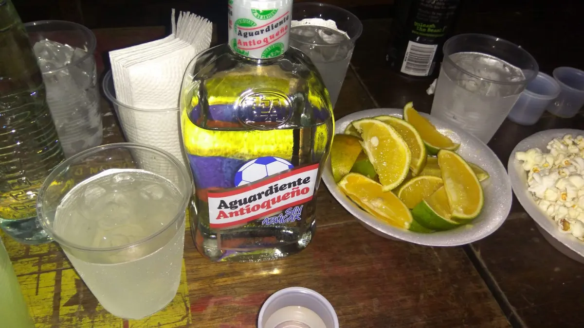 A table at Son Havana with a bottle of Aguardiente Antioqueño, glasses of ice, lime wedges and a bowl of popcorn.